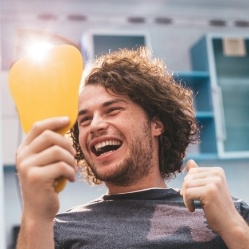 Man looking at smile in mirror