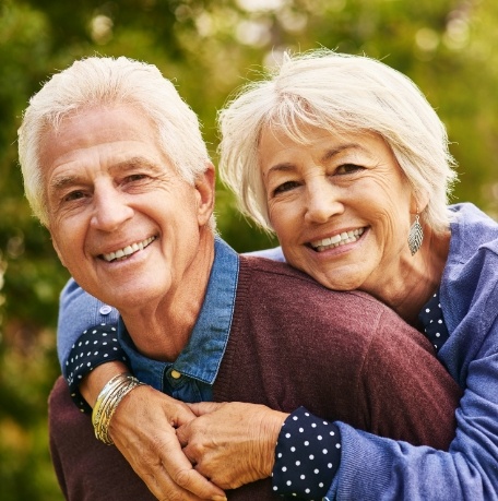 Older man and woman with all on four dental implants smiling together