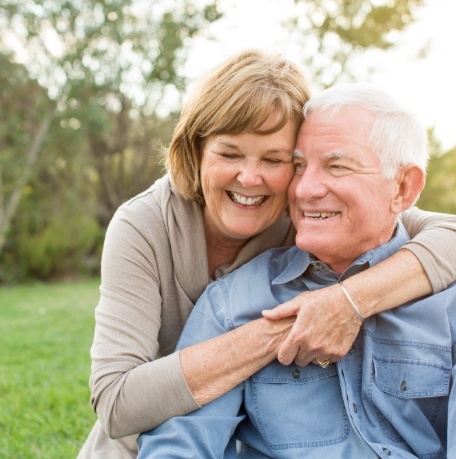 Older couple smiling together outdoors