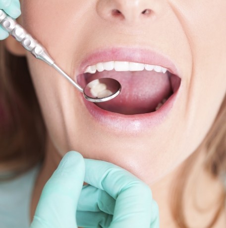 Dentist examining smile after metal free dental restoration