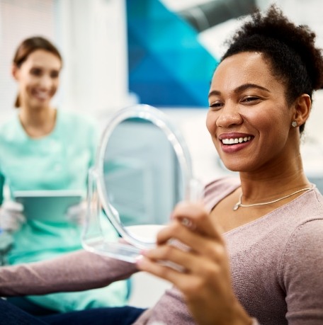 Woman looking at her smile after makeover