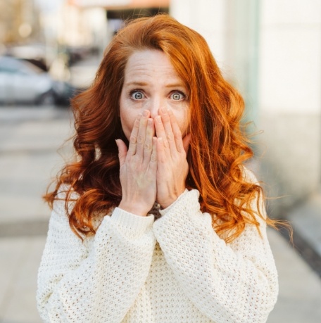 Woman in need of cosmetic dentistry hiding her smile