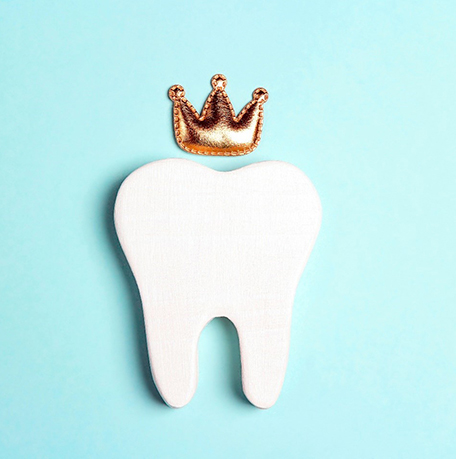 a tooth with a royal crown against a blue background