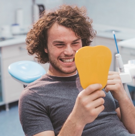 Man looking at smile during dental checkup and teeth cleaning visit