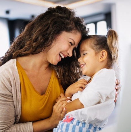 Mother and child smiling during dental checkup and teeth cleaning visit