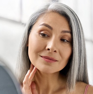 Dentures patient in Soldotna looking in the mirror