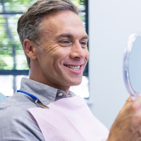 Man looking at smile in mirror