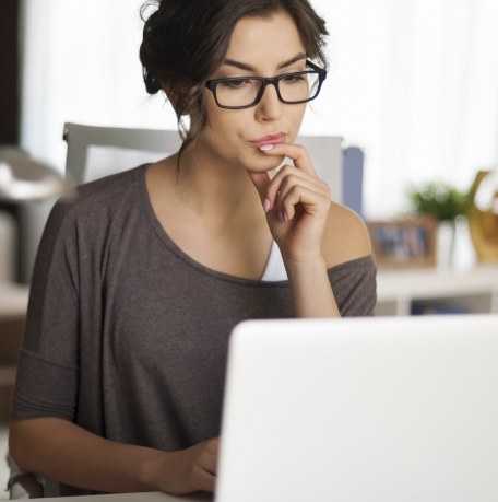 Woman considering the answers to frequently asked dentistry questions