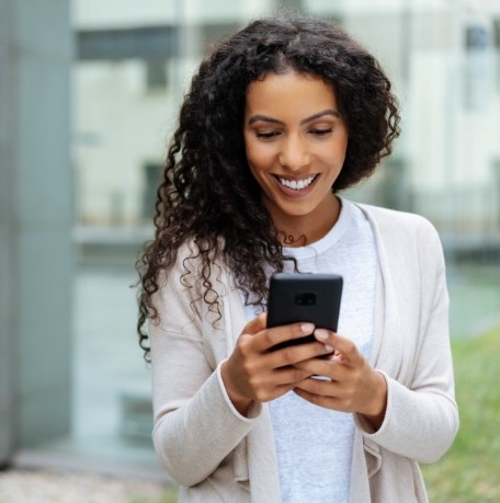 Woman smiling while scheduling dental appointment