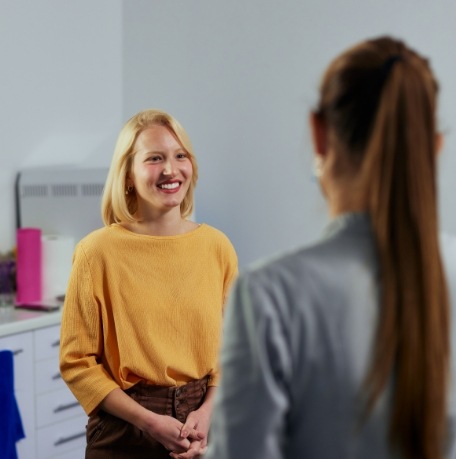 Woman smiling at dental team member