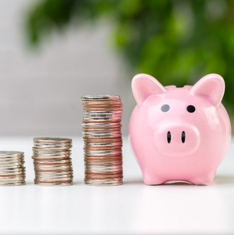 Piggy bank next to stacks of coins