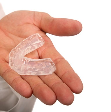 person holding mouthguard in hand 