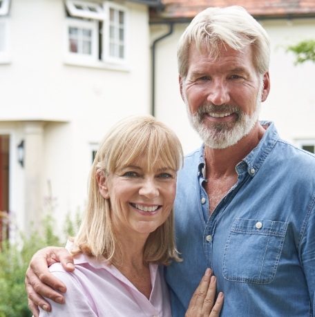 Man and woman with implant dentures smiling