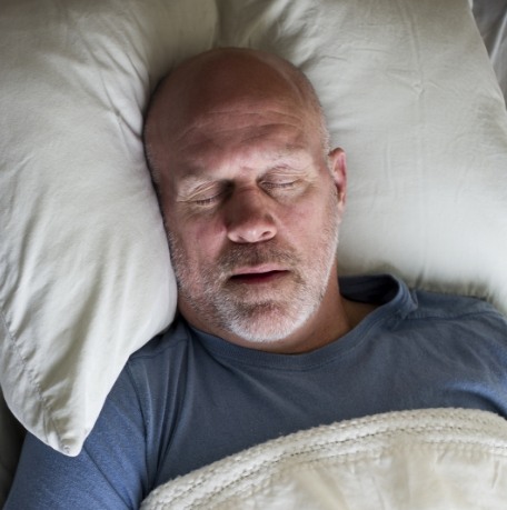 Man sleeping soundly thanks to sleep apnea treatment