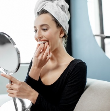 Woman using at home teeth whitening tray