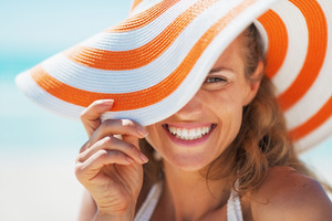 Woman in beach hat smiling during the summer